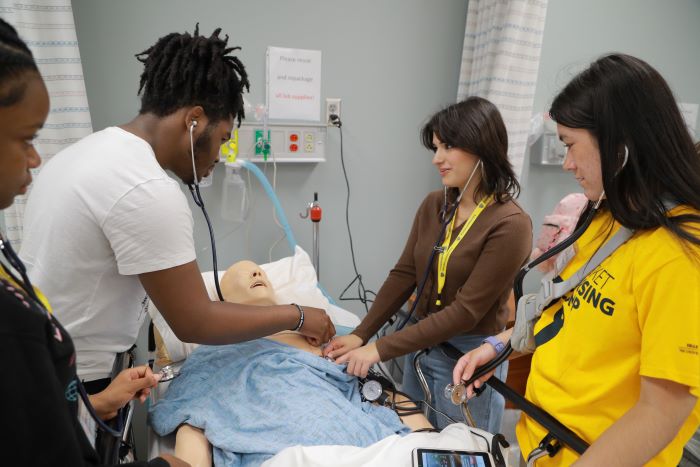 High School Students listening to lung sounds on a nursing mannequin