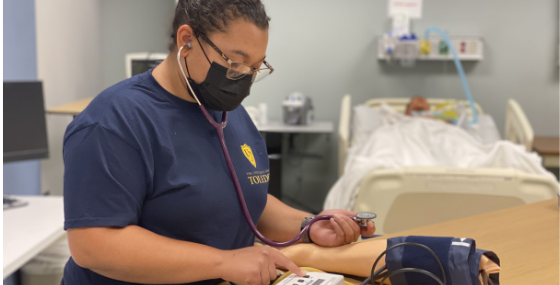 female student practicing blood pressure