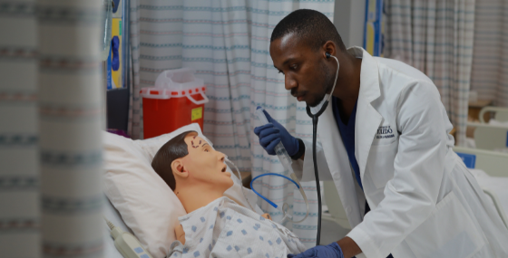 male student practicing listening to lung sounds