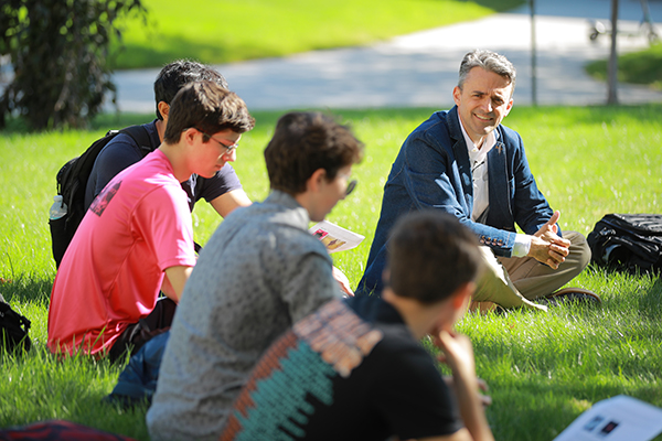 Honors professor teaching a group of students outside on a sunny day