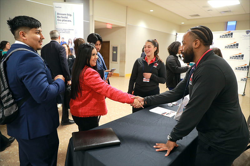 Two people shaking hands over a table