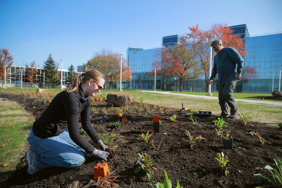 student and professor working in a garden