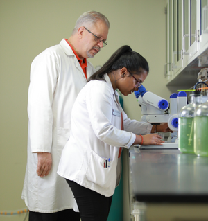 Dr. Williams working with a student at a microscope