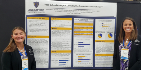 Faculty and alumni presenting a poster