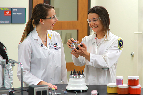 A cosmetic science student working with a professor in a lab