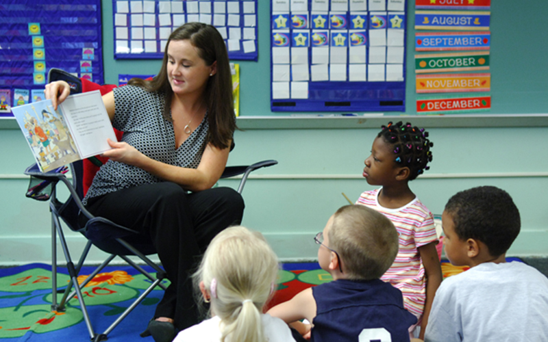 a teacher reads a picture book to a class of young students 
