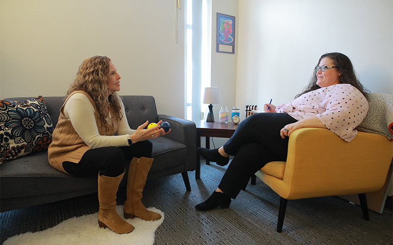 counselor sitting on couch talks to patient