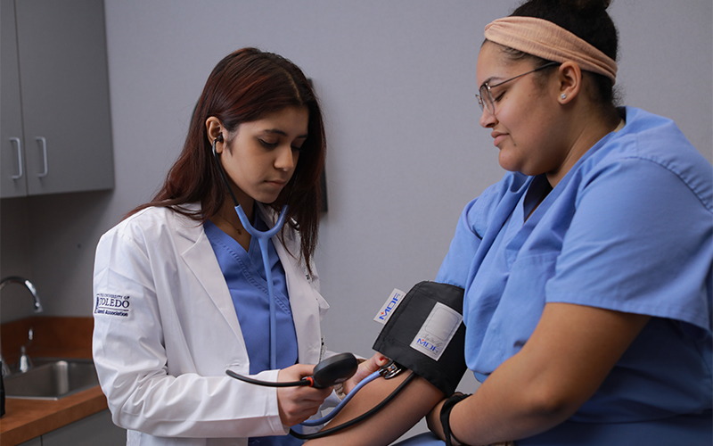 doctor obeserves blood pressure measurements of her patient