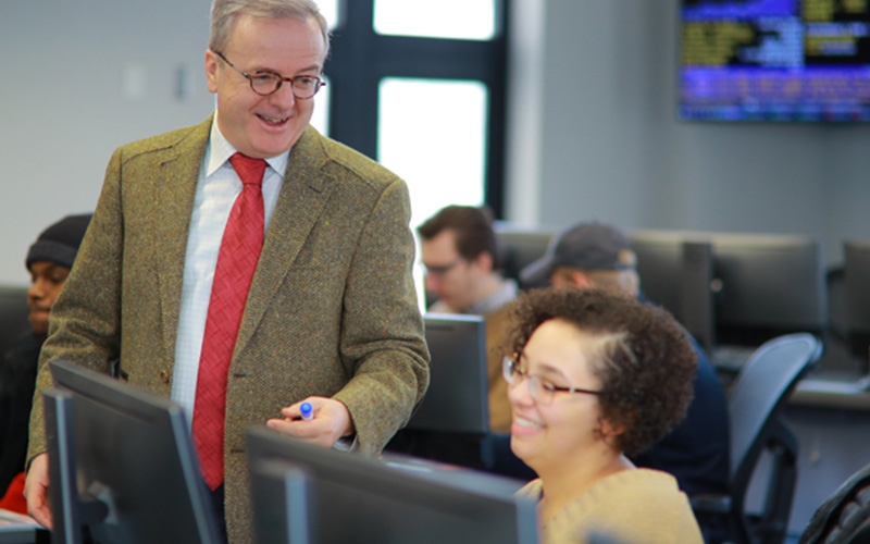professor talks to student in computer lab