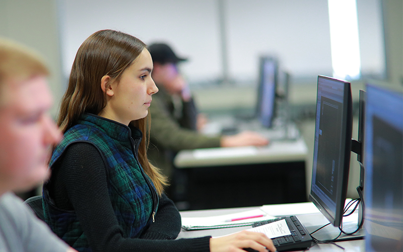 student at a computer lab station observes code