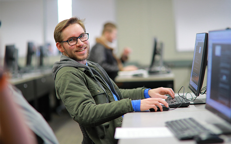 student sitting at computer in computer lab