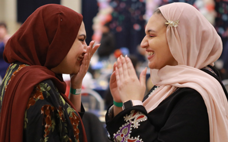 two international students smiling and laughing with one another