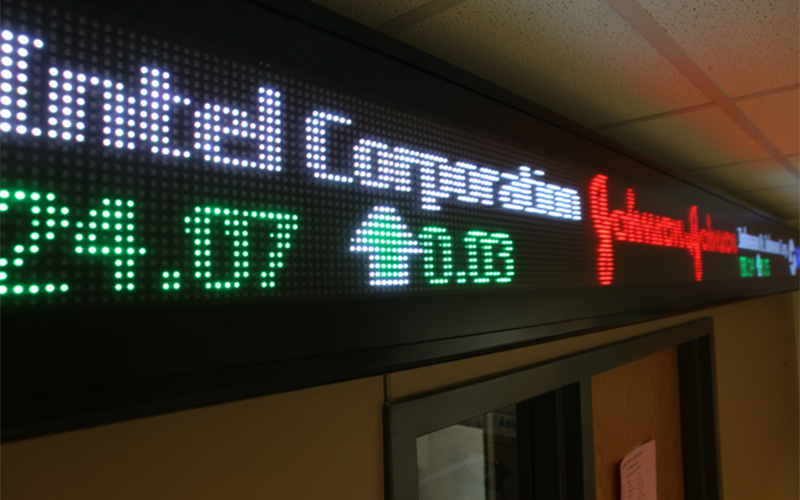 digital screen displaying live stock and wall street data