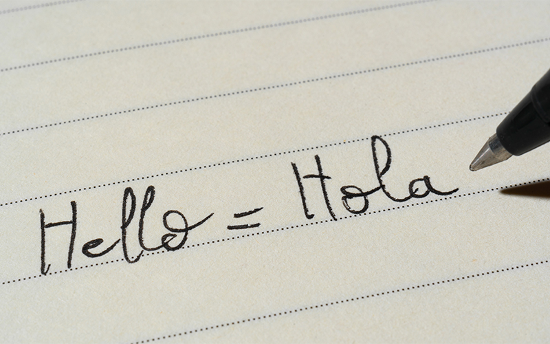 a Spanish translation for Hello equals Hola written in a notebook 