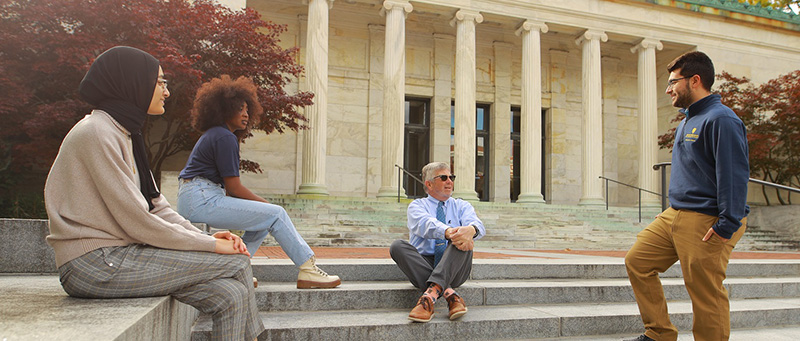 Honors students talking with an Honors professor on the steps of the Toledo Museum of Art