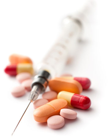 Image of prescription pills and a syringe to illustrate controlled substances and dangerous drugs
