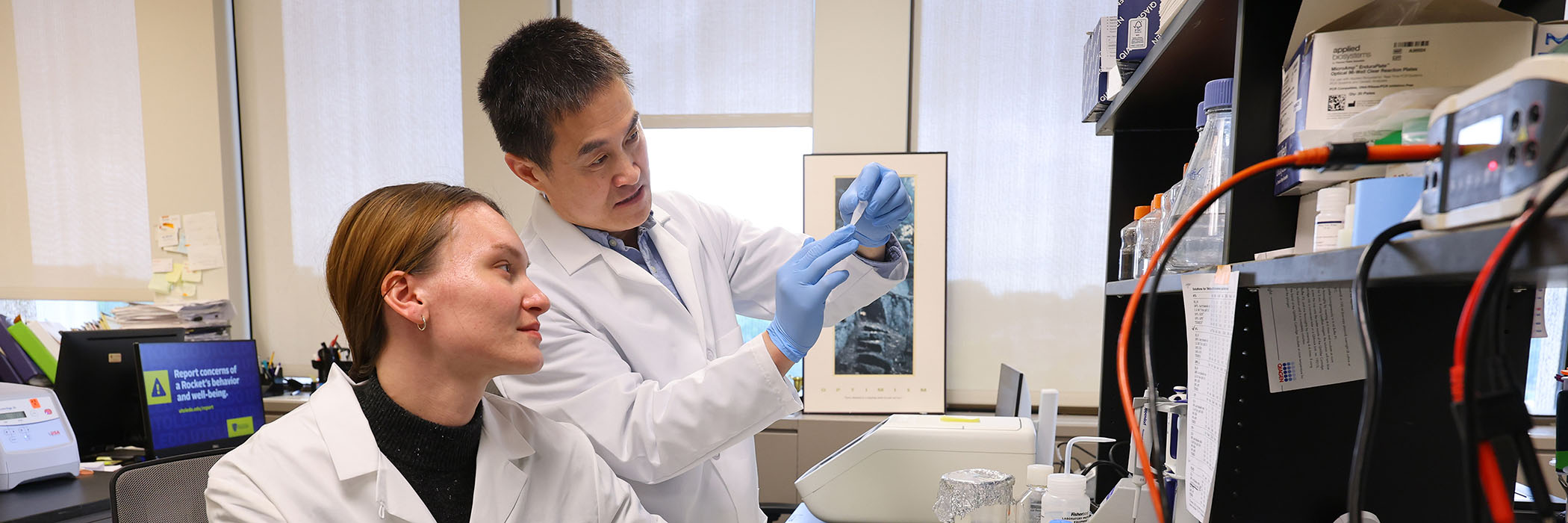 two doctors in a laboratory looking at a sample together surrounded by equipment