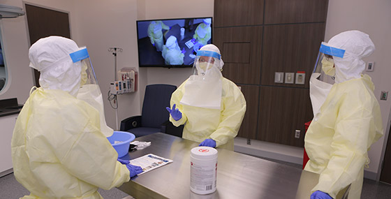 researchers in a lab with gown and masks on
