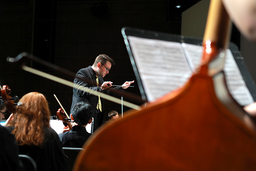 band director directing students playing instruments
