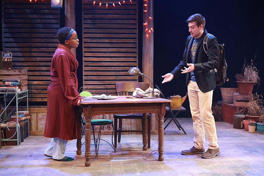 two students acting on stage dressed in costumes
