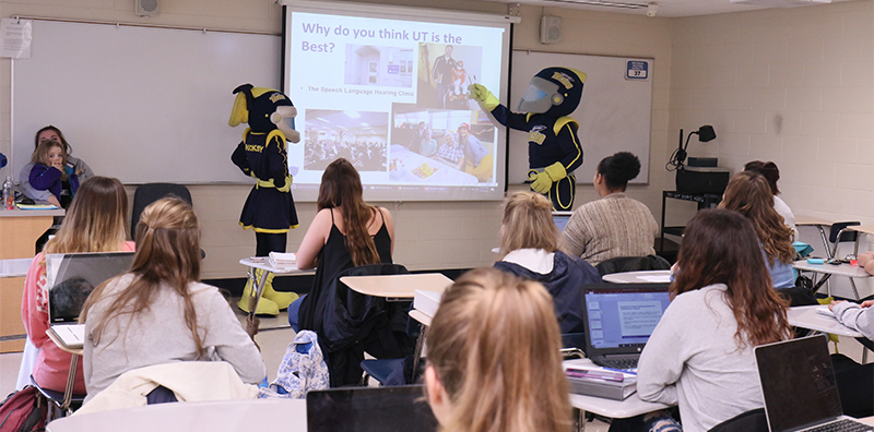 Rocky and Rocksy explaing on white board to students in classroom