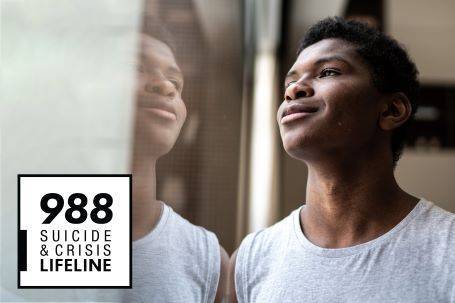 young man staring out a window