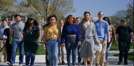 Group of 14 students standing in a horizontal line facing the camera