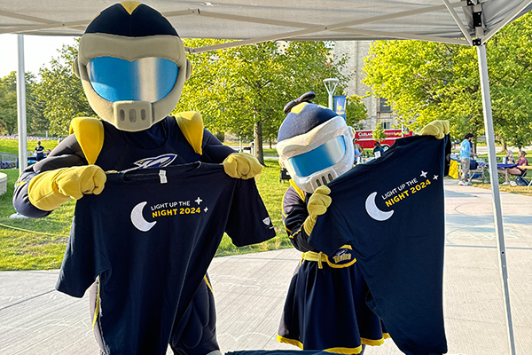 Rocky and Rocksy holding up tshirts in a community event booth