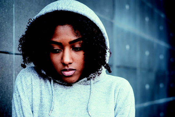 Person in hoodie looking depressed in the cold rain