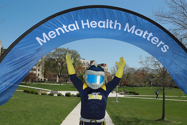 Rocky posing in front of a Mental Health Matters banner.