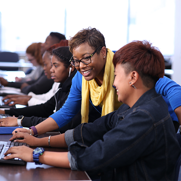 instructor helping a student on computer