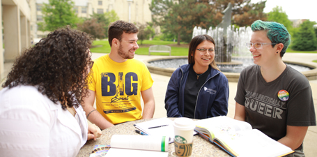 A diverse group of students sitting around a table outside of the student union