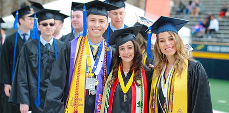 A group of smiling Latino graduates at UToledo's commencement
