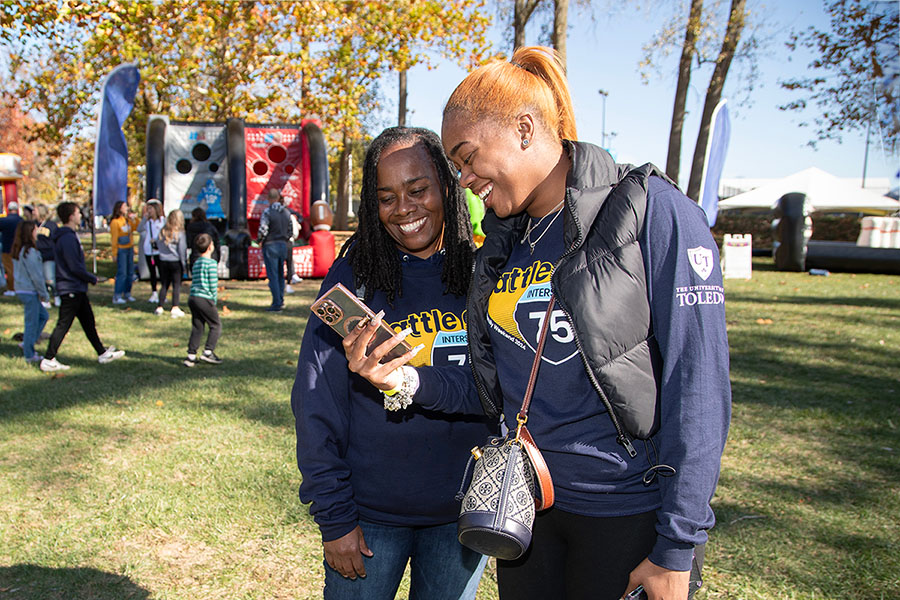 a mother and daughter taking a selfie and smiling on campus in fall during rocket family weekend
