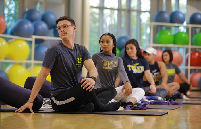 a group of students doing yoga in the Rec