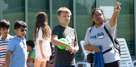 kids camp counselor giving directions to a camper