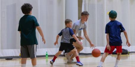 kids camp counselor playing basketball with campers