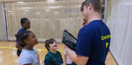 kids camp counselor talking with campers 