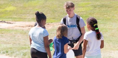 kids camp counselor talking with a group of campers