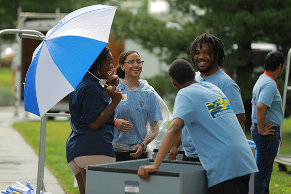 Housing staff standing outside with moving carts.