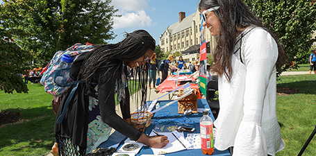 Students talking by the fountain in Student Union with University Hall in the background