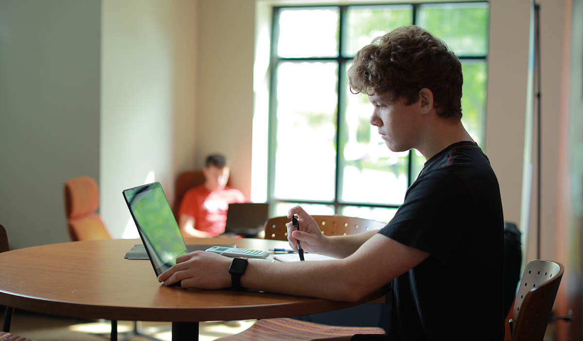 student sitting at laptop studying