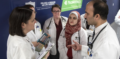 A faculty member speaking with a small group of medical students