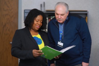 Two people reading a printed resource guide