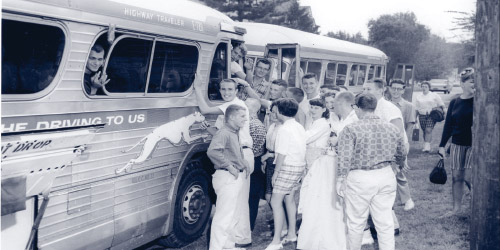 A black and white photo of some students boarding buses