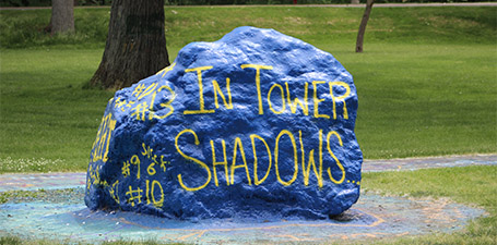 UToledo's spirit rock, painted blue with the words "in tower shadows" painted in gold